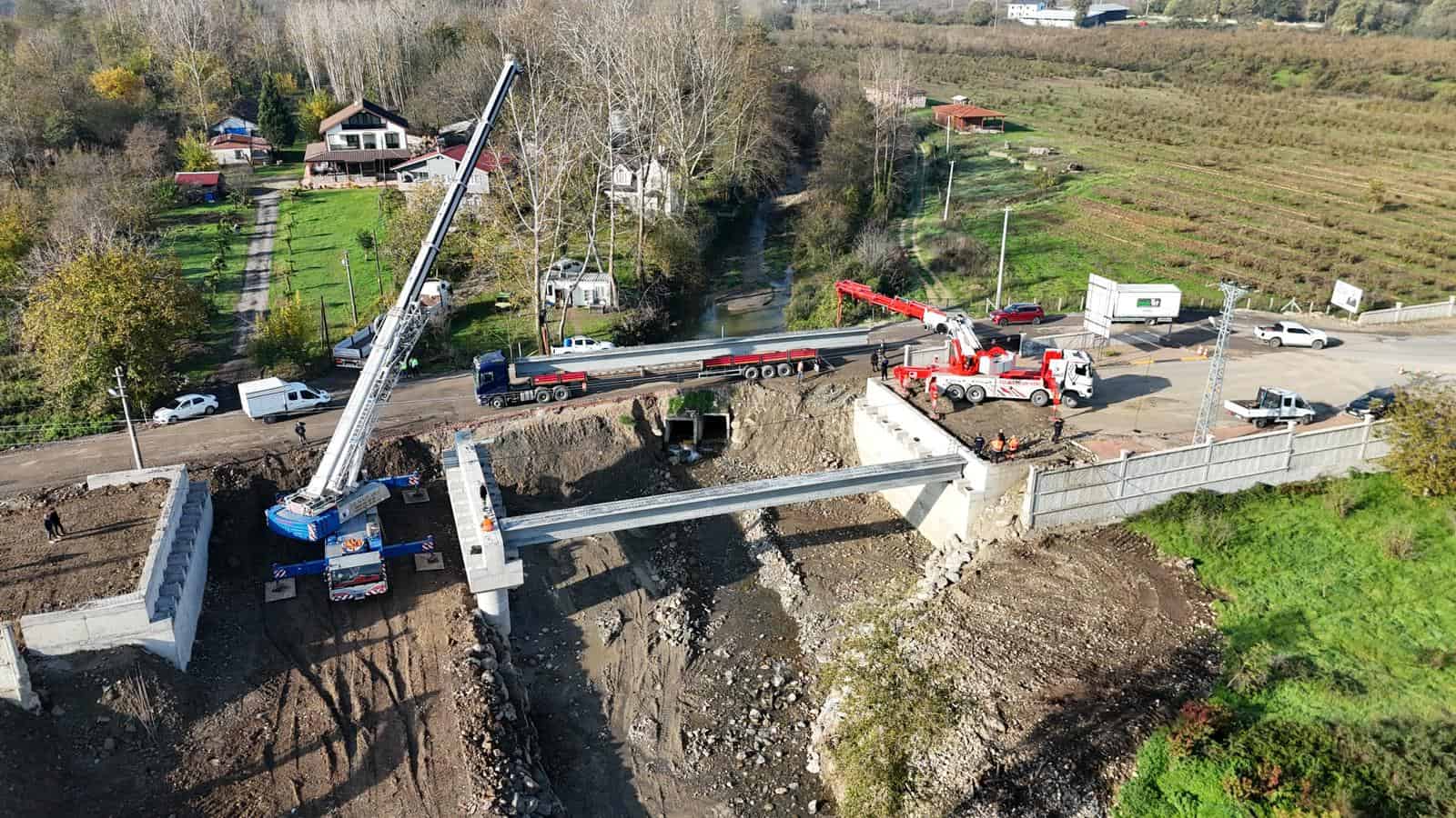 Köprü inşaatında vinç ve iş makineleri kullanılarak yapı çalışmaları devam ediyor.